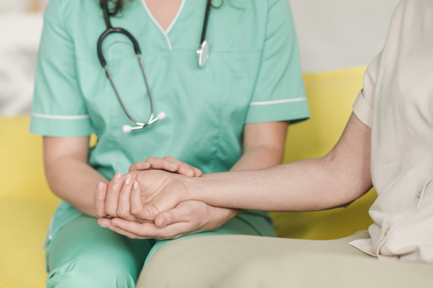 nurse checking pulse female patients wrist