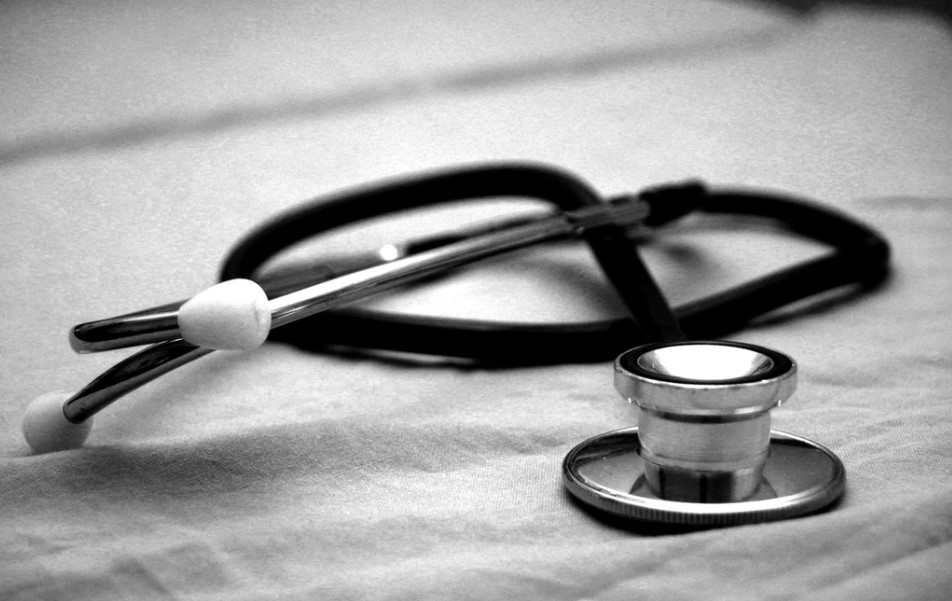 black and white image of a stethoscope on a white cloth
